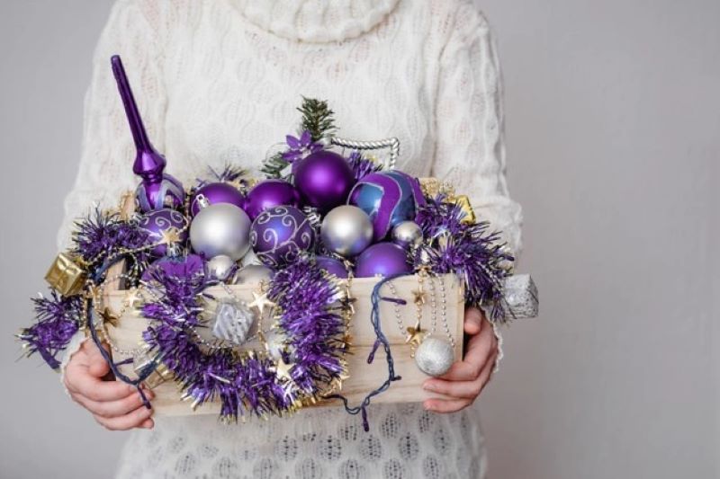 female holding box full purple decor